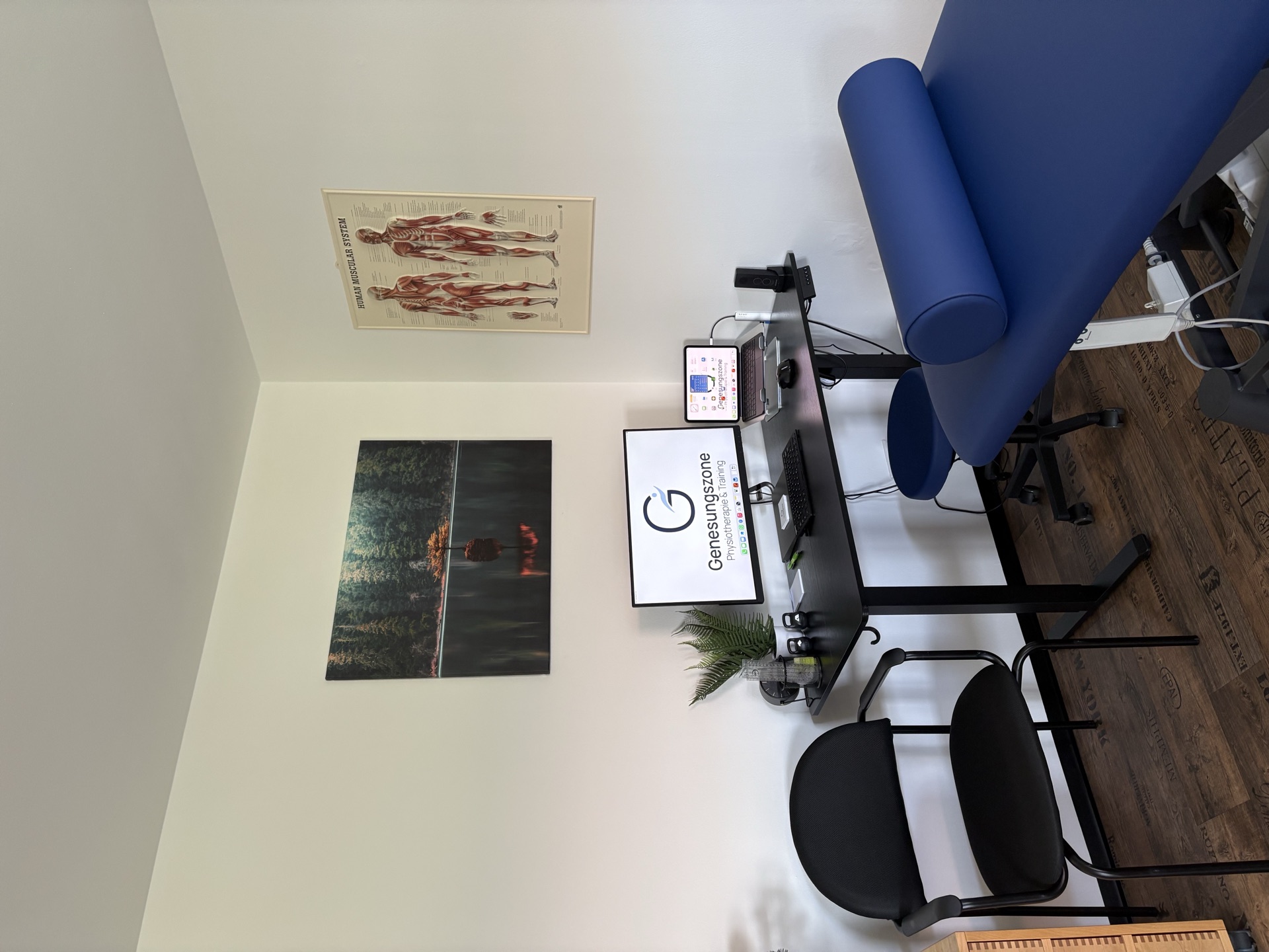 Behandlungsraum mit Therapieliege und Arbeitsplatz